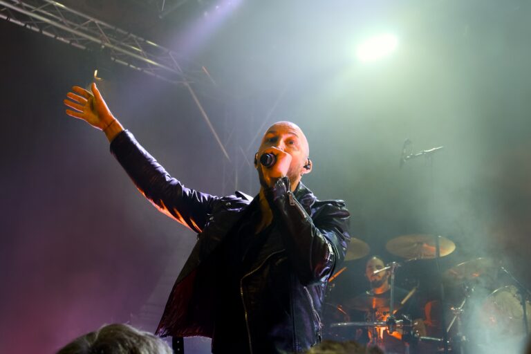 Der Sänger der Band Soen hält seine Hand bei einem Konzert nach oben.