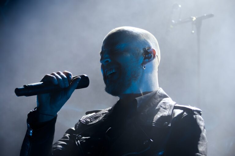 Joel Ekelöf von der Band Soen hält bei einem Konzert ein Mikrofon in der Hand.